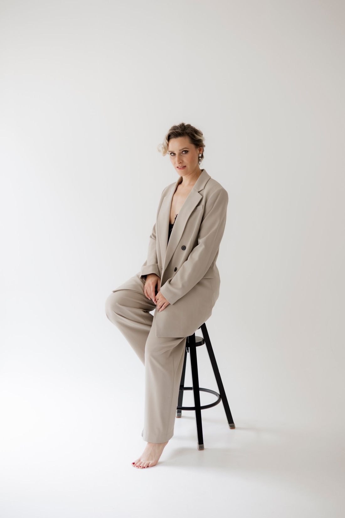 Martha Eason seated on a stool in a cream suit